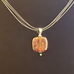 Silpada An Amber, Black Onyx Pendant on a four Strand Black Leather Necklace.